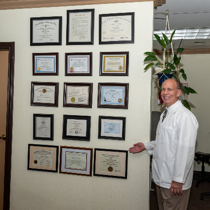 Dr. Robert Hulbert by wall of awards