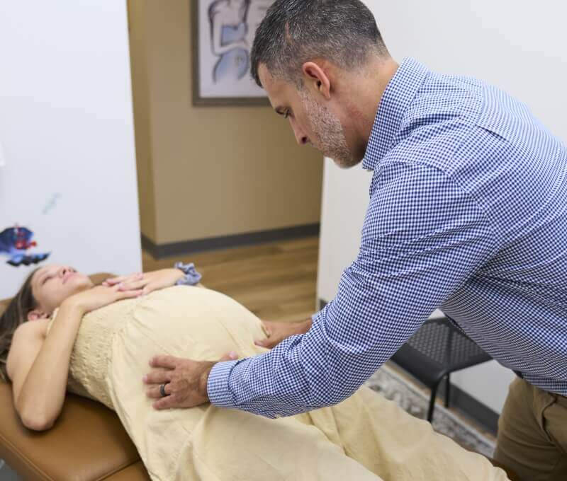 North Charleston chiropractor Dr. Tyler Wilt adjusting pregnant patient