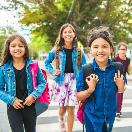 Girls with backpacks walking to school