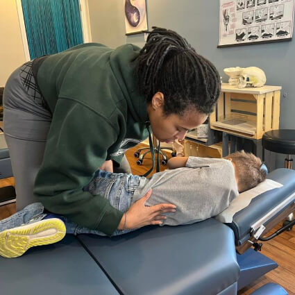 Riverwell Chiropractic Chiropractor Dr. Makeda adjusting child