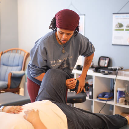 Lawrenceville Chiropractor Dr. Makeda holding patient's leg