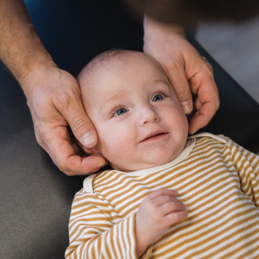 baby having neck touched by chiropractor