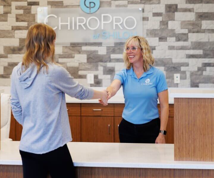 ChiroPro team welcoming patient at front desk