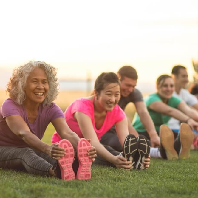 People sitting on grass stretching their legs