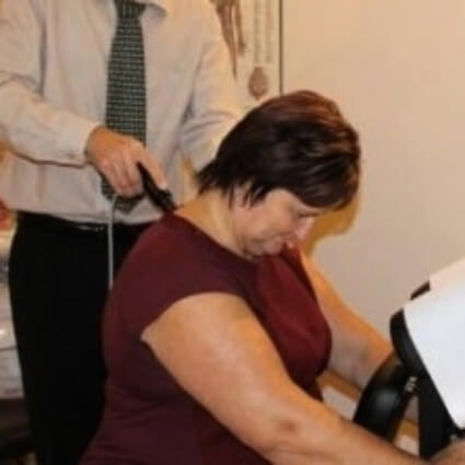 Beacon Hill Chiropractic Clinic patient havint adjusting tool used on their neck