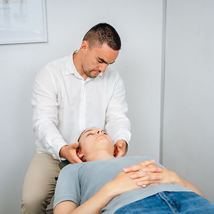 Male chiro adjusting neck of woman