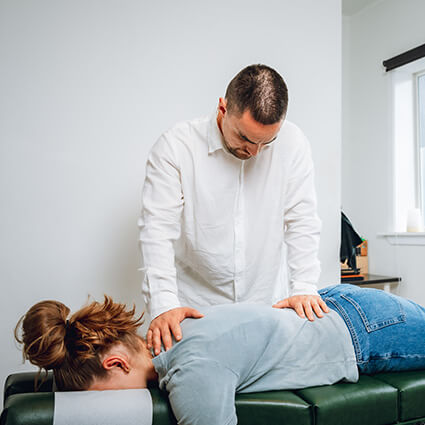 Male chiro adjusting upper lower back