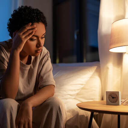 woman-unable-to-sleep-sitting-on-bed-sq