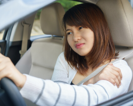 Woman with painful shoulder driving car