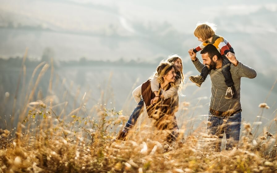 happy family of four hiking outdoors