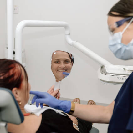 person smiling in hand mirror