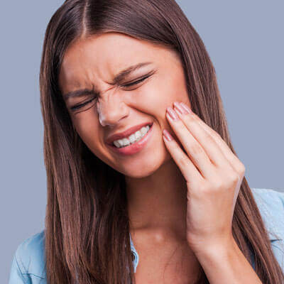 woman grimacing with jaw pain