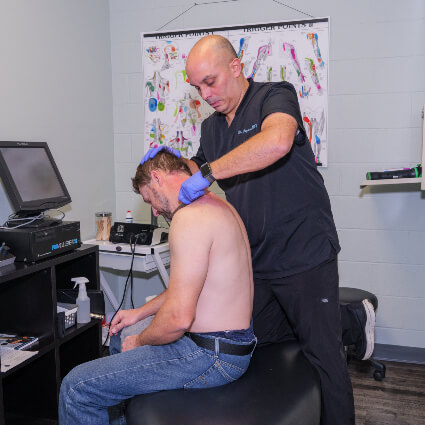 Chiropractor using graston technique on patient