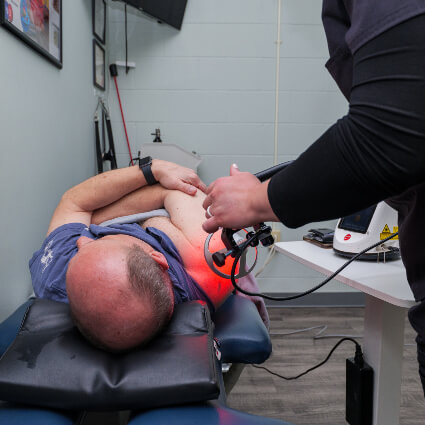 Man on table receiving laser therapy