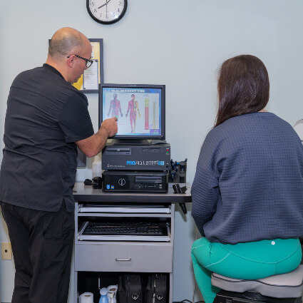 Chiropractor pointing to results on screen