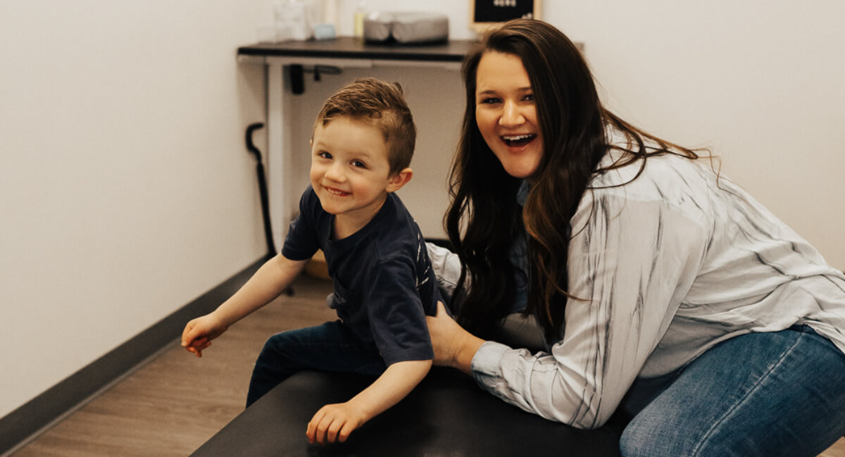 Chiropractor adjusting young boy's back