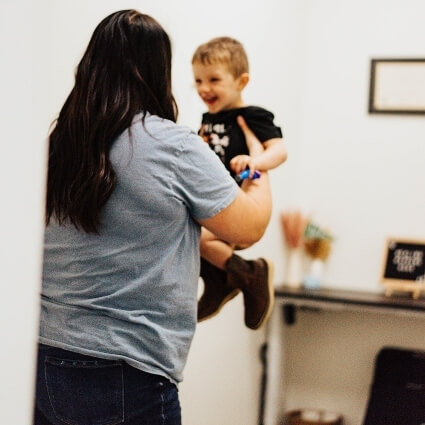 Woman lifting up little boy