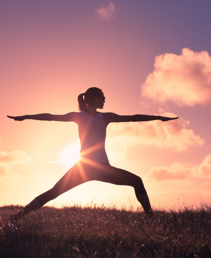 Woman stretching outside during sunset