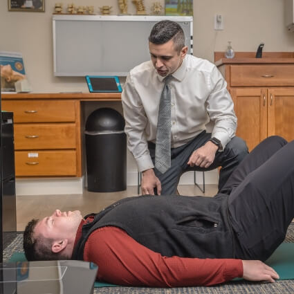 Campbell chiropractor helping patient who is laying down