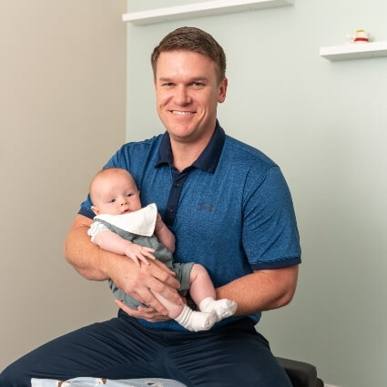 chiropractor holding baby