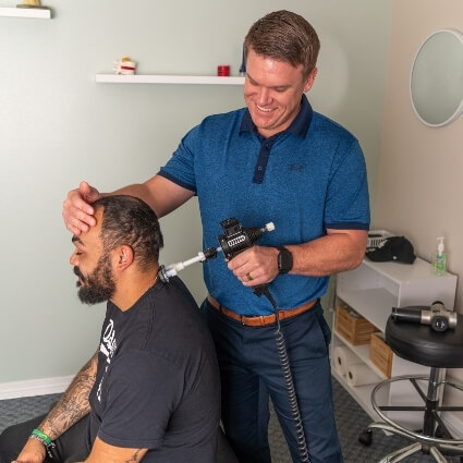 Our chiropractor adjusting patients neck with tool
