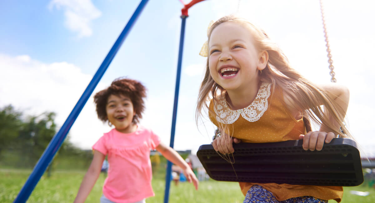 Young girls playing on swing