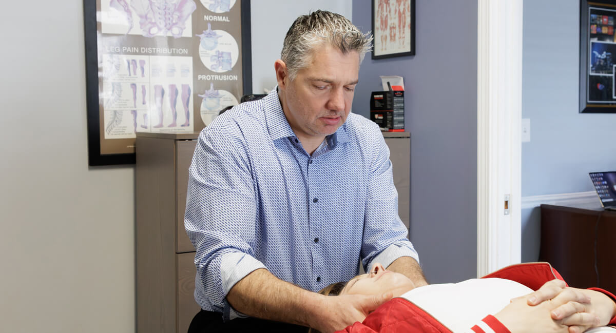 Dr. Fast giving female patient a neck adjustment