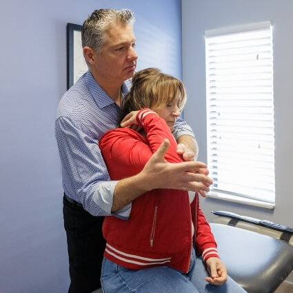 Female patient receiving an arm adjustment