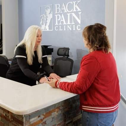 Receptionist discussing paperwork with patient