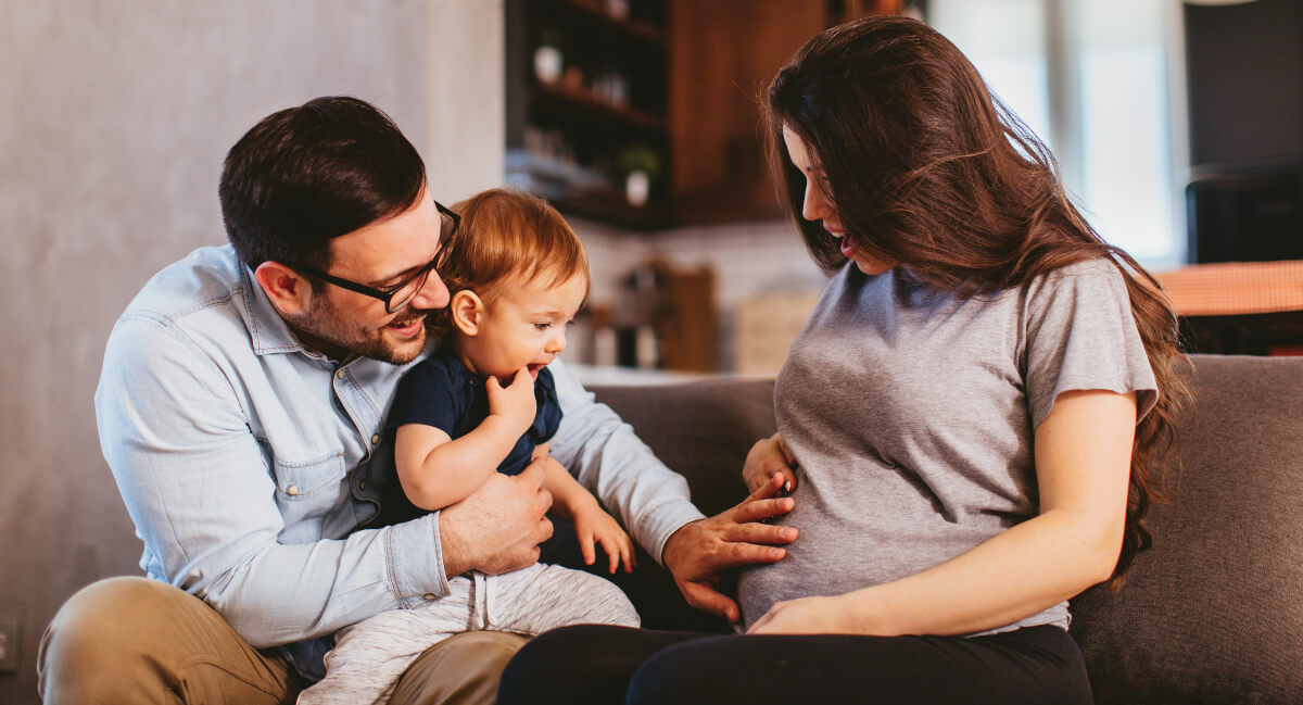 Smiling husband touching his pregnant wife's belly