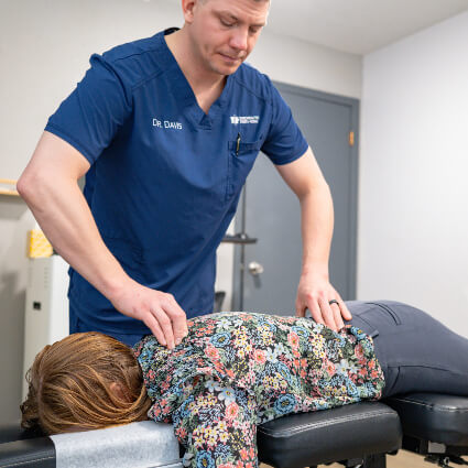 Sioux City Chiropractor Dr. Davis adjusting woman on table