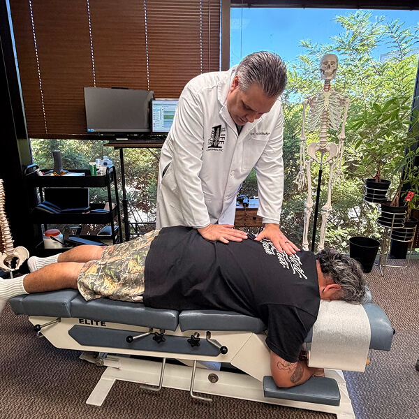 Canoga Park Chiropractor Dr. Michael Wohlmaker adjusting patient's back