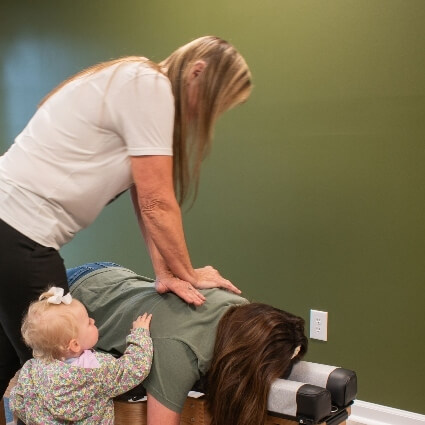 chiropractor adjusting patients back