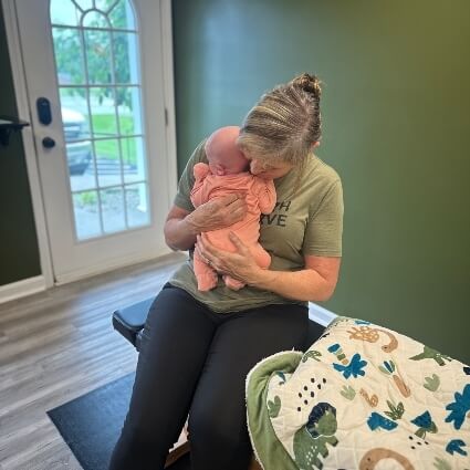 chiropractor holding baby