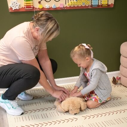chiropractor and child adjusting stuffed animal
