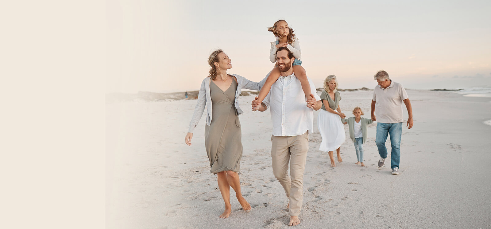 multigenerational happy family walking on the beach