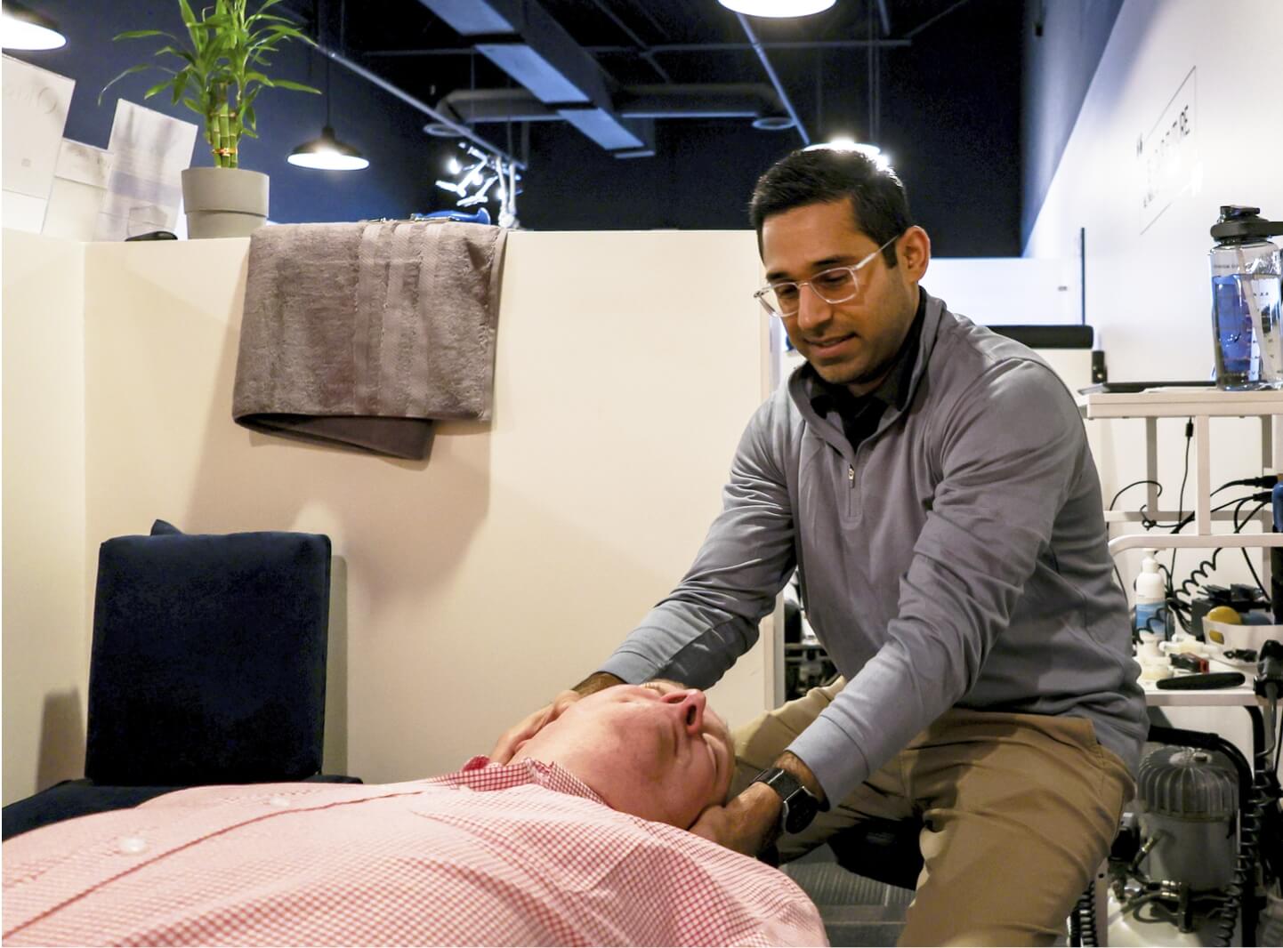 Flowery Branch chiropractor Dr. Pranav adjusting male patient's neck