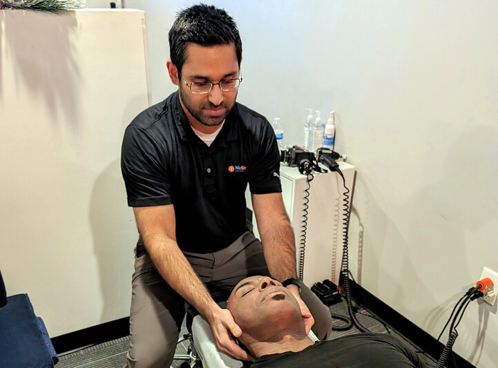 Flowery Branch chiropractor Dr. Pranav adjusting male patient's neck