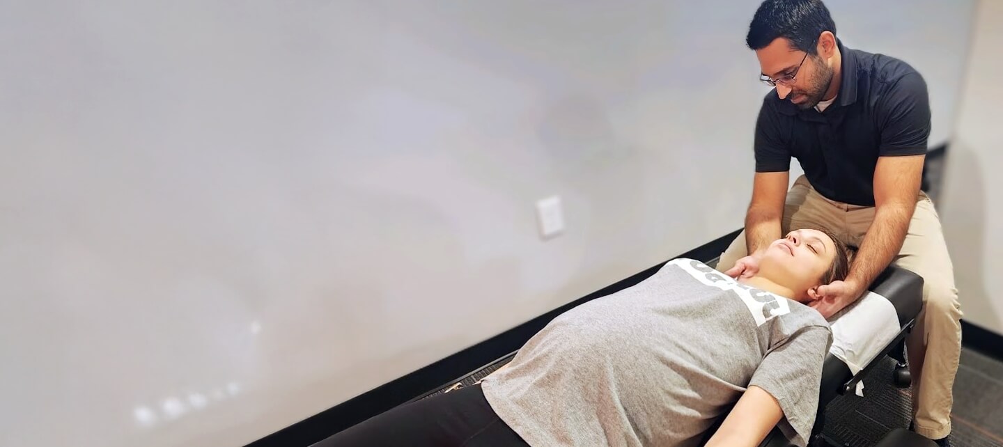 Female patient receiving a relaxing neck adjustment by Dr. Pranav