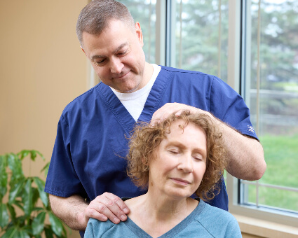 Dr. Tim adjusting woman's head