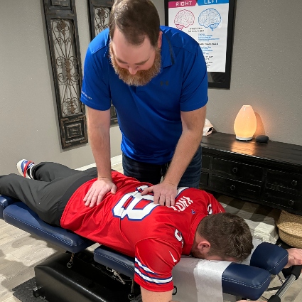 Dr Sorenson adjusting patients back