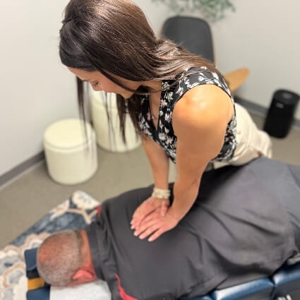 our chiropractor adjusting patients upper back