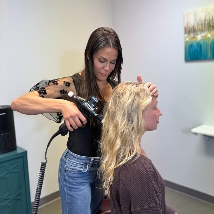 our chiropractor adjusting patients neck with tool