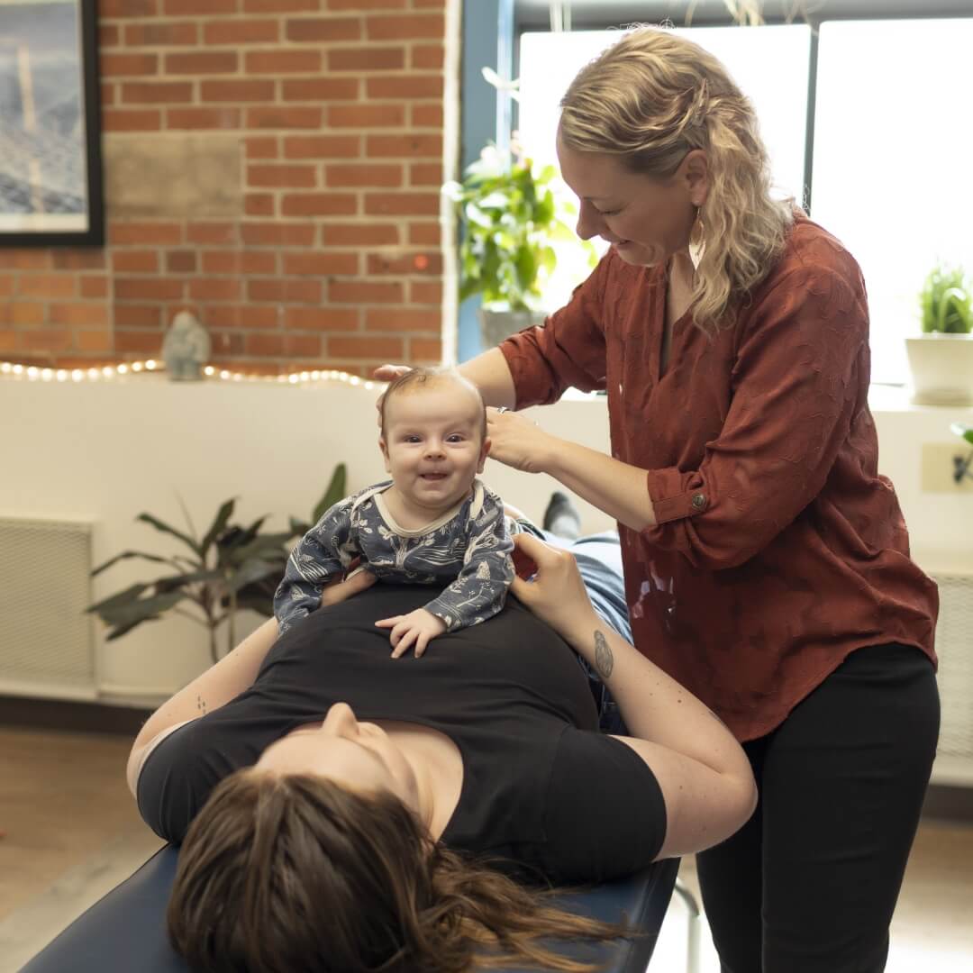 Keene chiropractor adjusting baby on mom's stomach