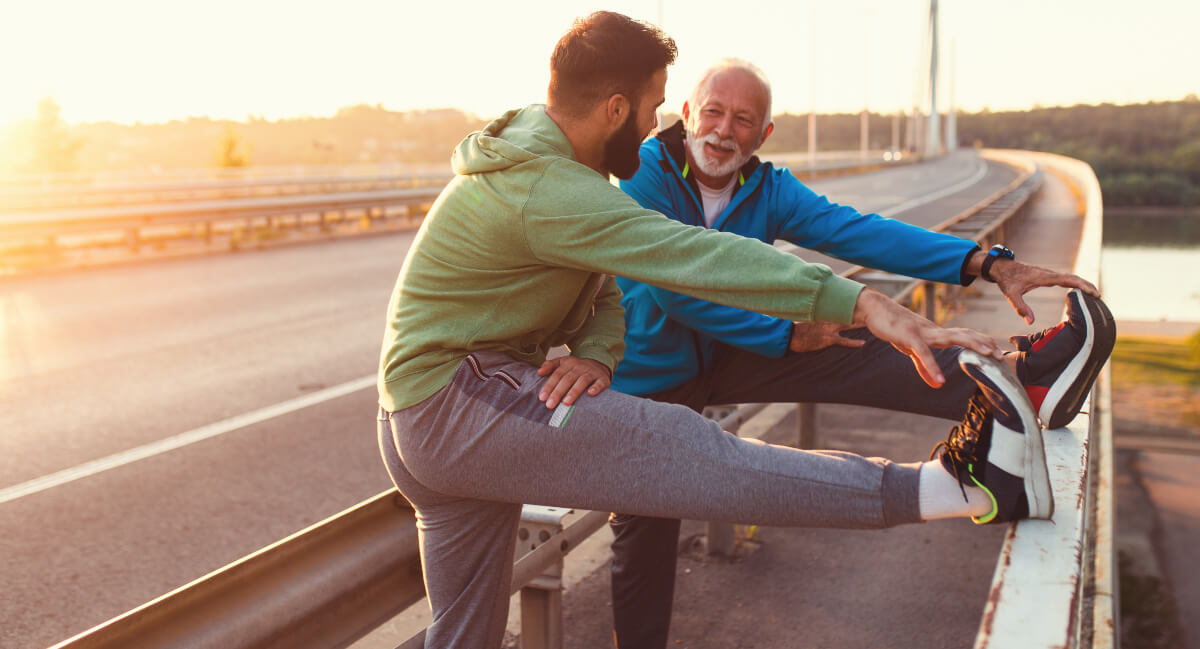 Two male joggers stretching their legs