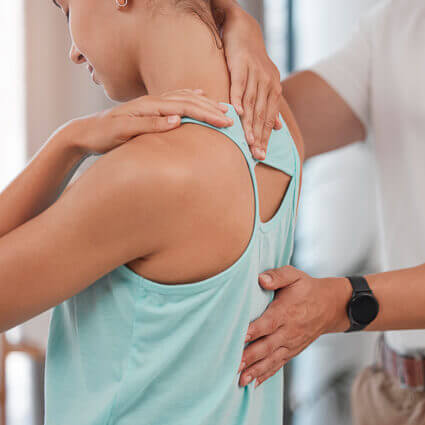 woman in blue tanktop having upper back examined