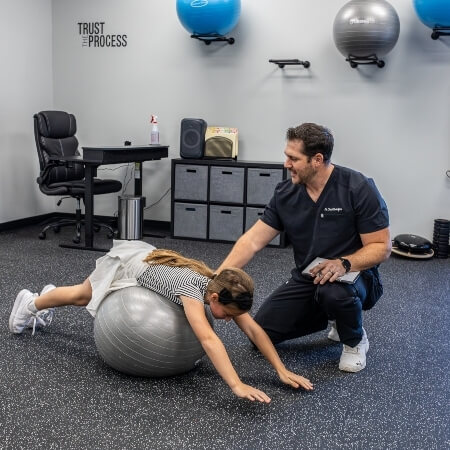 Dr Chad with girl on physio ball