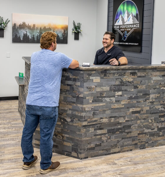 Peak Performance Sport & Spine patient talking to our chiropractor at our front desk