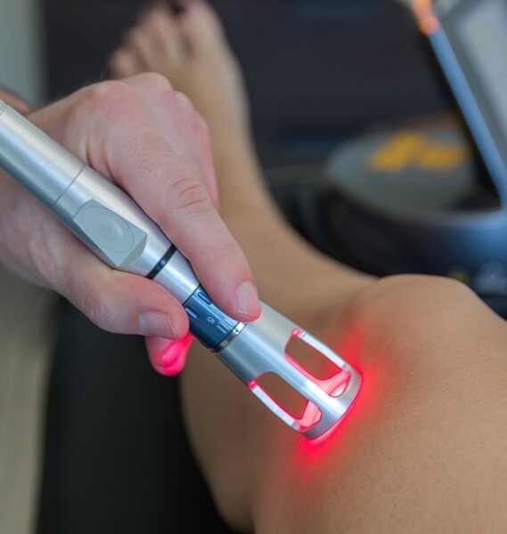 person getting laser treatment on knee