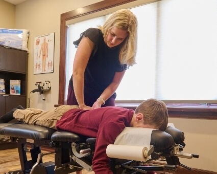 Pediatric patient receiving back adjustment